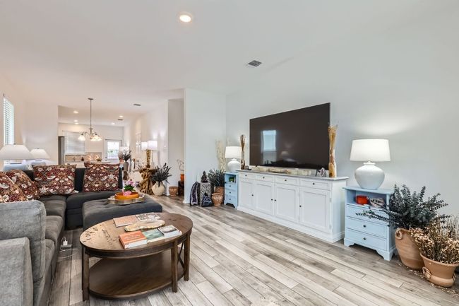 Living area with a chandelier, light wood-type flooring, plenty of natural light, and recessed lighting | Image 7