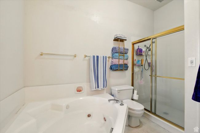 Full bath featuring toilet, a shower stall, and a whirlpool tub | Image 15