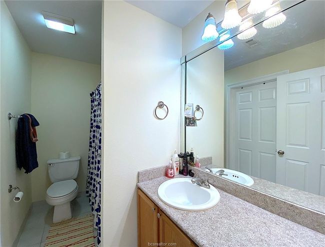 Full bath with toilet, vanity, a shower with shower curtain, and tile patterned floors | Image 10