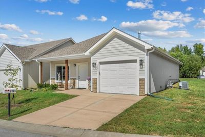 Ranch-style house featuring cooling unit, a garage, covered porch, and a front yard | Image 2