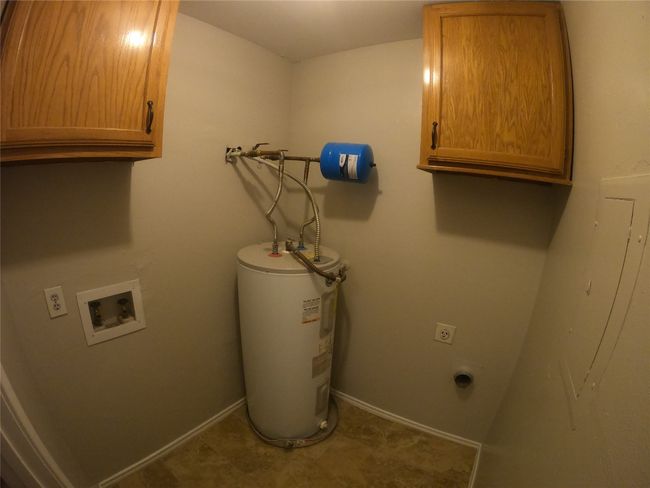 Clothes washing area with electric dryer hookup, cabinet space, water heater, washer hookup, and baseboards | Image 8