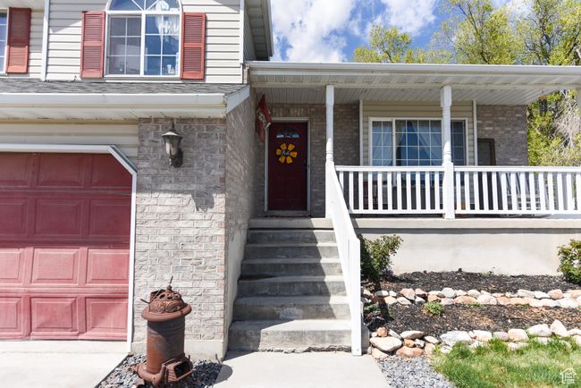 Entrance to property with a garage, brick siding, and a porch | Image 7