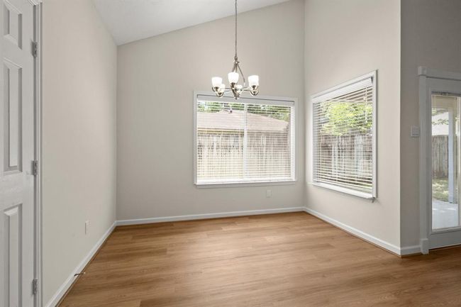 Adjacent to the kitchen, the dining area flows effortlessly into the living space, boasting new light fixtures | Image 18