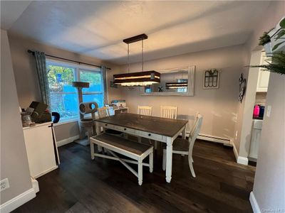 Dining room featuring a baseboard heating unit and dark hardwood / wood-style flooring | Image 3