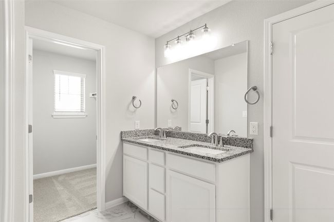 Full bath featuring double vanity, baseboards, and marble look tiles | Image 22