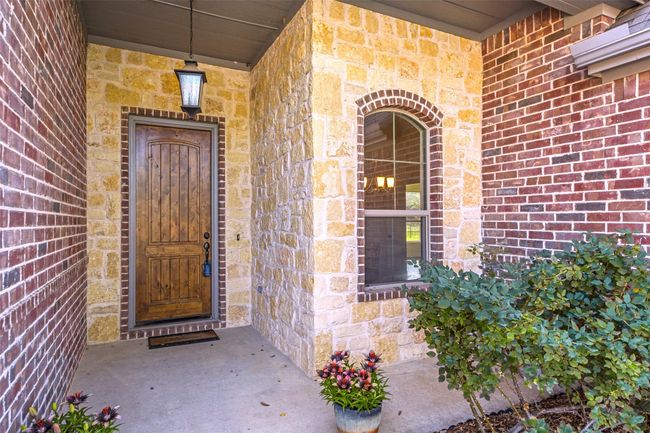 A closer view of this front porch area with handsome wood door! | Image 4