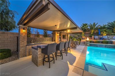 An entertainer's paradise awaits in this backyard, boasting an incredible covered living space with a full bar area, all seamlessly flowing right next to the sparkling pool! | Image 3