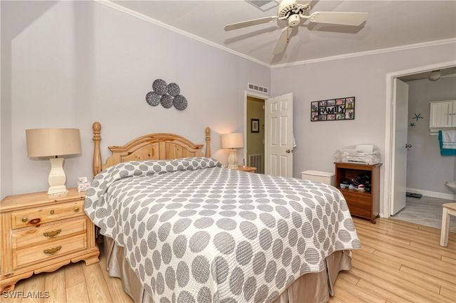 Bedroom with connected bathroom, ceiling fan, light hardwood / wood-style flooring, and ornamental molding | Image 14