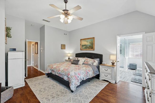 Bedroom featuring vaulted ceiling, dark wood-style floors, baseboards, and a ceiling fan | Image 15