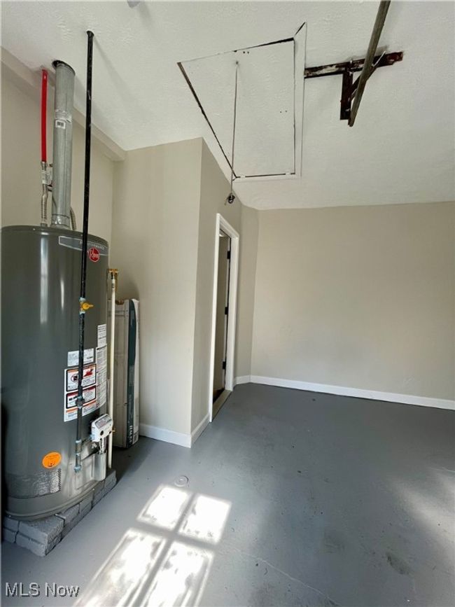 Garage with gas water heater and baseboards | Image 26