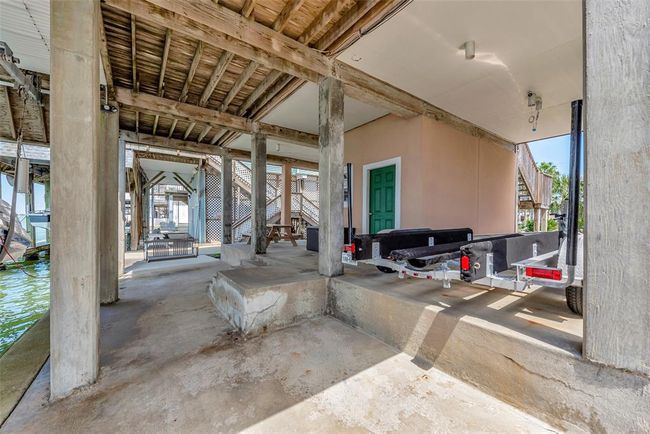 Underneath the home, you'll find a spacious covered deck and carport area that’s perfect for staying cool in the shade. There’s room for a trailer, seating, and easy access to the dock. | Image 32