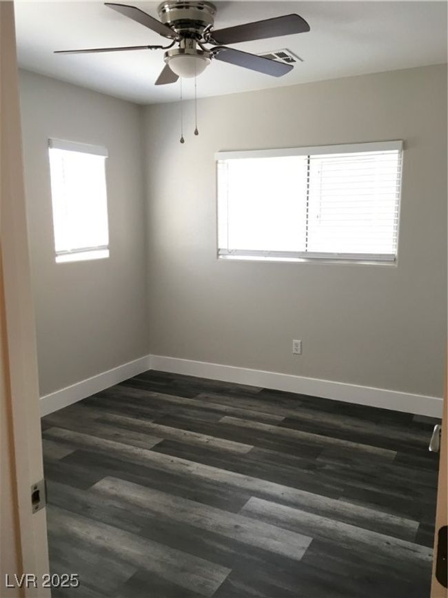 Spare room with baseboards, ceiling fan, and dark wood-style flooring | Image 19