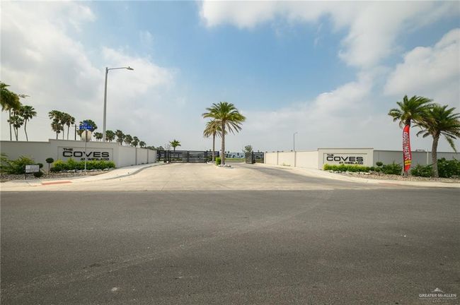 View of asphalt road with street lighting, curbs, sidewalks, and a gated entry | Image 22