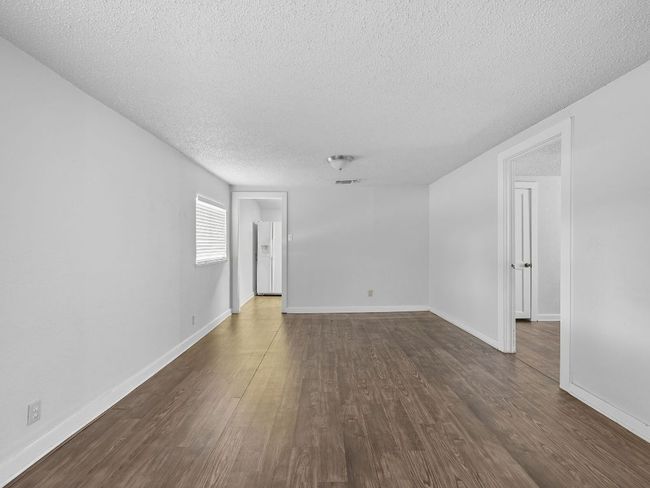 Unfurnished room with a textured ceiling and dark wood-type flooring | Image 13