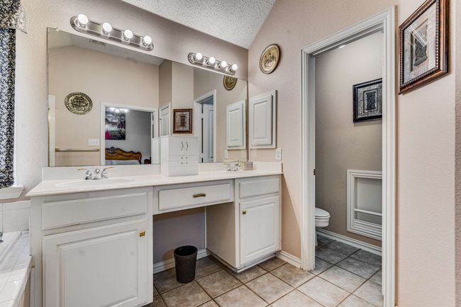 Bathroom featuring double vanity, tile patterned floors, toilet, linen closet and ensuite bath | Image 27