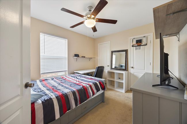 Bedroom featuring light colored carpet and a ceiling fan | Image 22