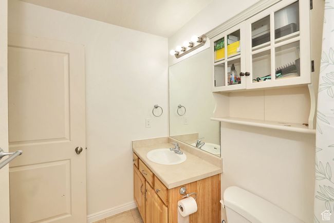 Bathroom featuring toilet, tile patterned floors, vanity, and baseboards | Image 24