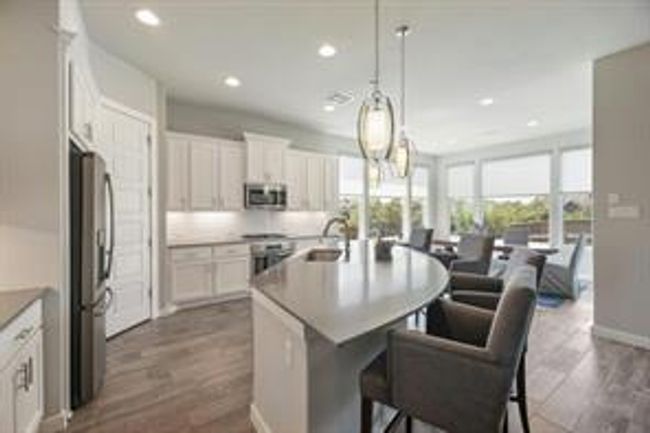 Kitchen with appliances with stainless steel finishes, a kitchen island with sink, recessed lighting, dark wood-style flooring, and pendant lighting | Image 9