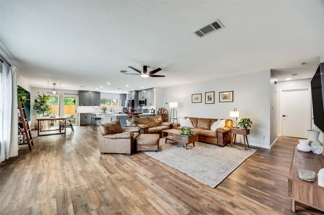 Living room with wood finished floors, ceiling fan, baseboards, and recessed lighting | Image 6