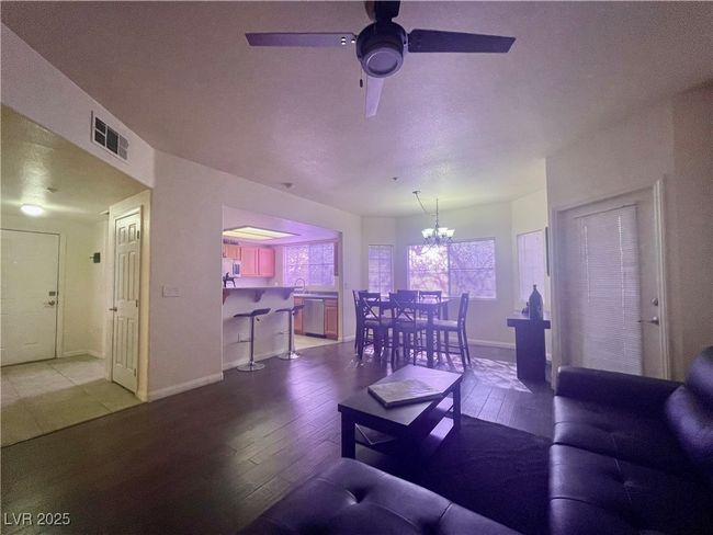 Living room featuring baseboards, ceiling fan with notable chandelier, wood-type flooring, and visible vents | Image 17