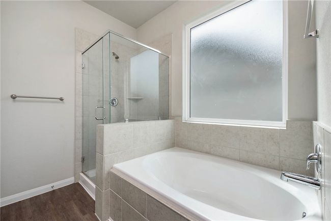 Full bathroom with a bath, a shower stall, and wood finished floors | Image 14