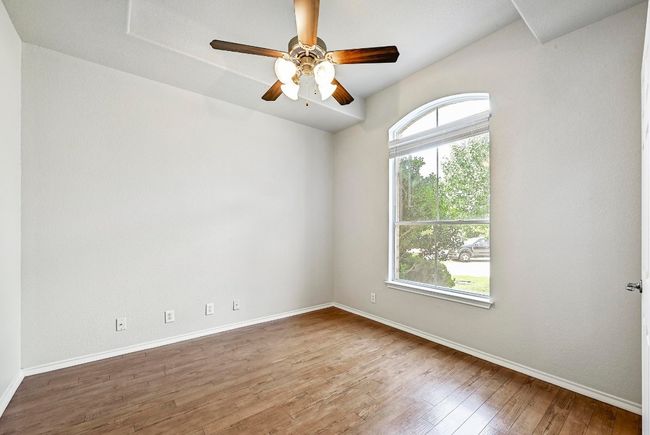 Empty room with wood-type flooring and a ceiling fan | Image 11