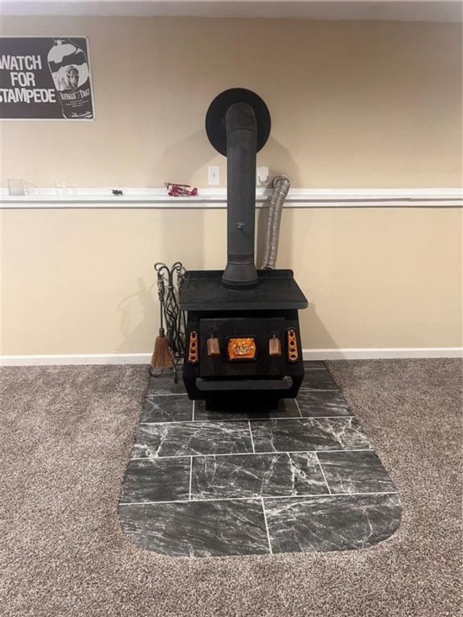 Detailed view of a wood stove and baseboards | Image 25