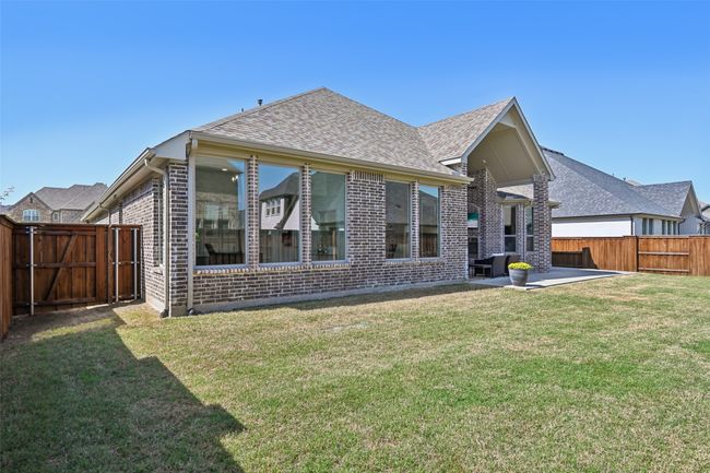 Back of property with brick siding, a patio area, a shingled roof, and a fenced backyard | Image 37