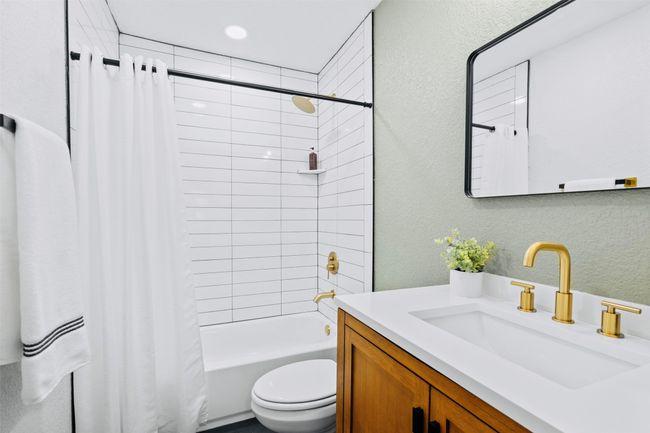 Bathroom featuring a textured wall, vanity, shower / bath combo with shower curtain, and recessed lighting | Image 32