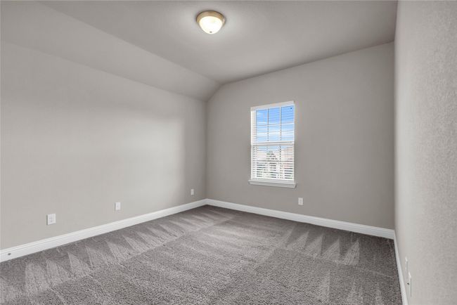 Unfurnished room featuring carpet flooring, baseboards, and lofted ceiling | Image 22