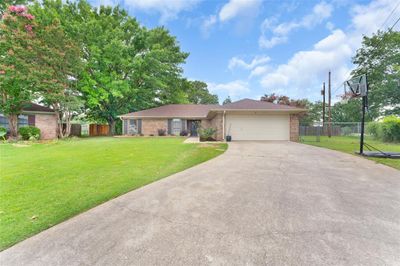 Ranch-style house with a garage and a front yard | Image 2