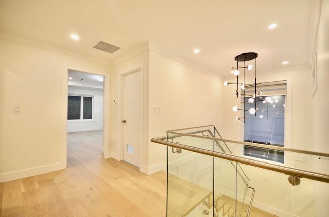 Hall featuring light wood finished floors, crown molding, recessed lighting, and an upstairs landing | Image 24