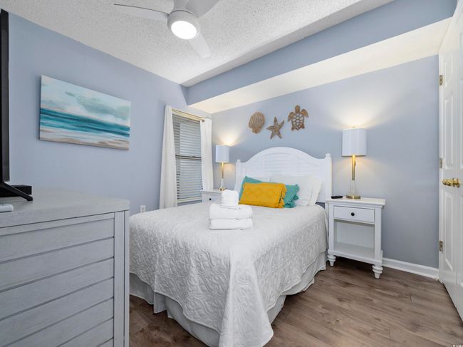 Bedroom featuring a ceiling fan, wood finished floors, baseboards, and a textured ceiling | Image 15