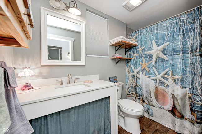 bathroom in the carriage house featuring vanity, a shower with curtain, visible vents, toilet, and wood finished floors | Image 56