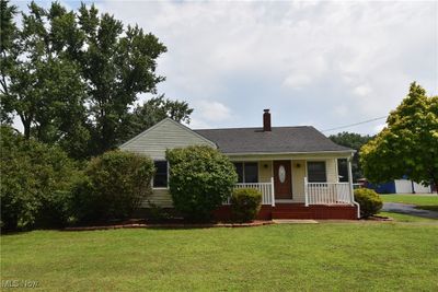 View of front facade featuring a porch, a garage, and a front yard | Image 2