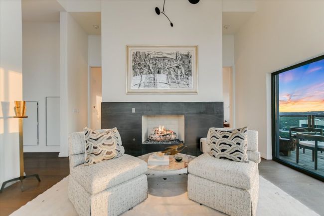 A sleek, modern fireplace anchors the space, adding warmth and ambiance to the expansive living area. | Image 5