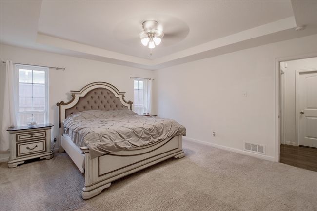 Carpeted bedroom featuring a raised ceiling and ceiling fan | Image 16