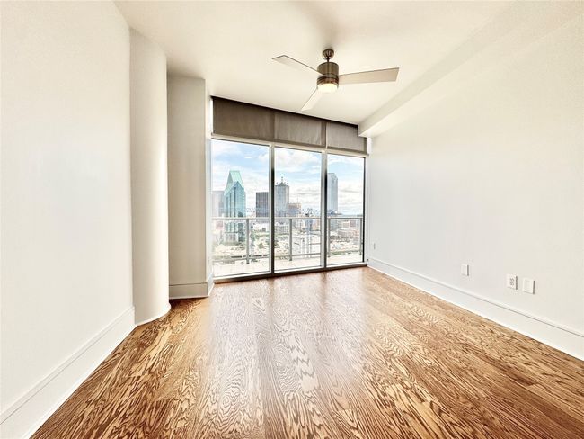 Spare room featuring a ceiling fan, wood finished floors, a skyline view, and baseboards | Image 17