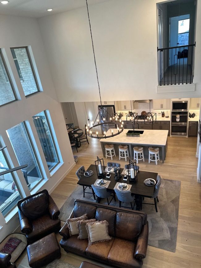 Living room featuring a notable chandelier, light wood finished floors, and a high ceiling | Image 12