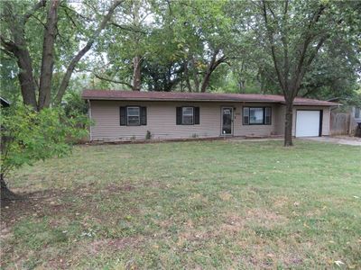 Ranch-style house with a front lawn and a garage | Image 2