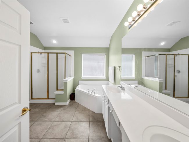Full bathroom featuring a stall shower, visible vents, tile patterned flooring, vaulted ceiling, and a sink | Image 20