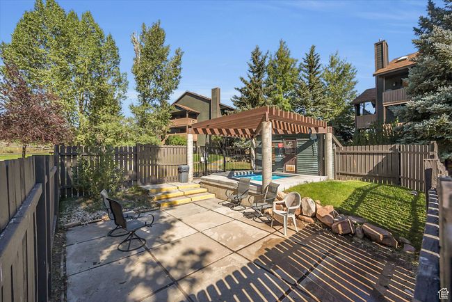 View of patio with a fenced in pool, a fenced backyard, and a pergola | Image 22