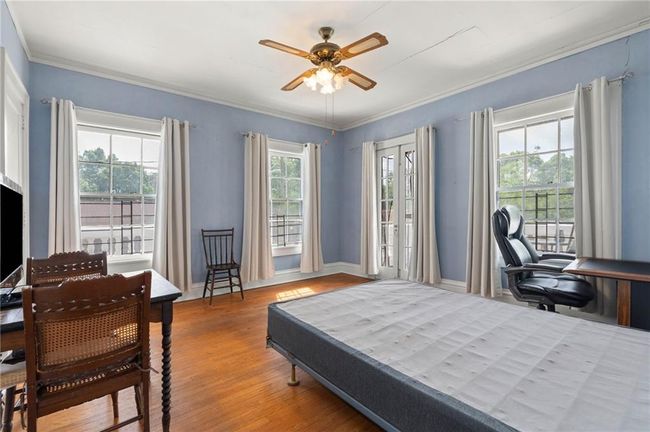 Bedroom with hardwood floors, crown molding, and baseboards. | Image 22