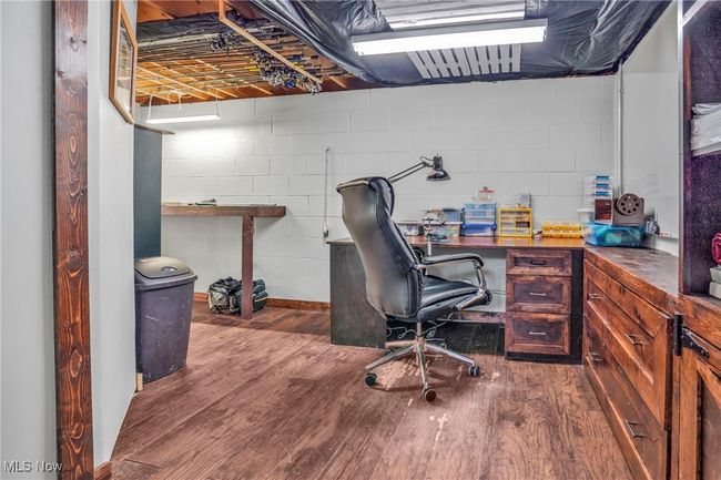 Office area with wood finished floors and concrete block wall | Image 31
