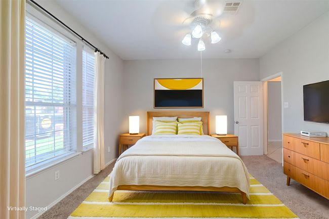 Bedroom featuring light carpet and ceiling fan *Virtually Staged* | Image 7