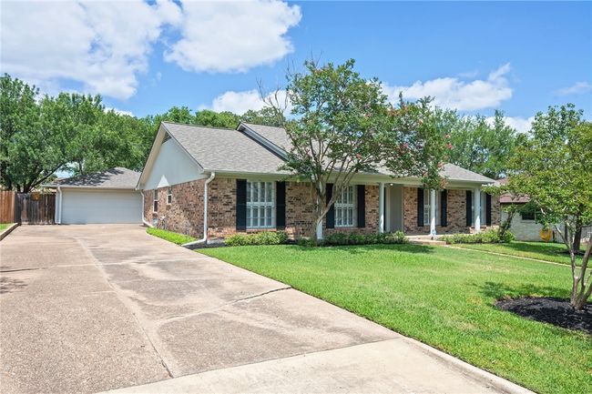 Ranch-style house with brick siding, roof with shingles, and a detached garage | Image 23