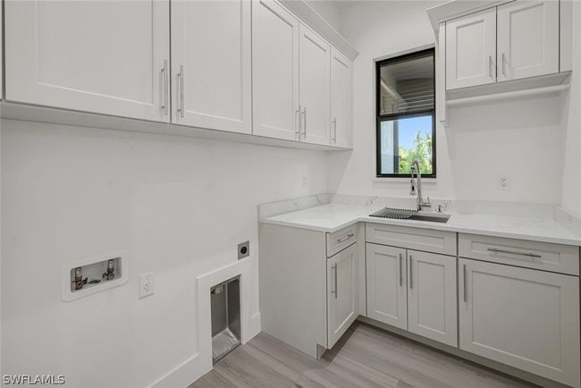 Laundry room with Quartz countertops, shaker style cabinets, stainless steel sink with pulldown faucet and storage cabinets galore. | Image 16