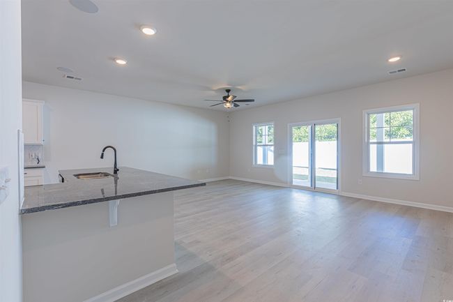 Kitchen with visible vents, a sink, dark stone counters, light wood-style floors, and white cabinets | Image 18