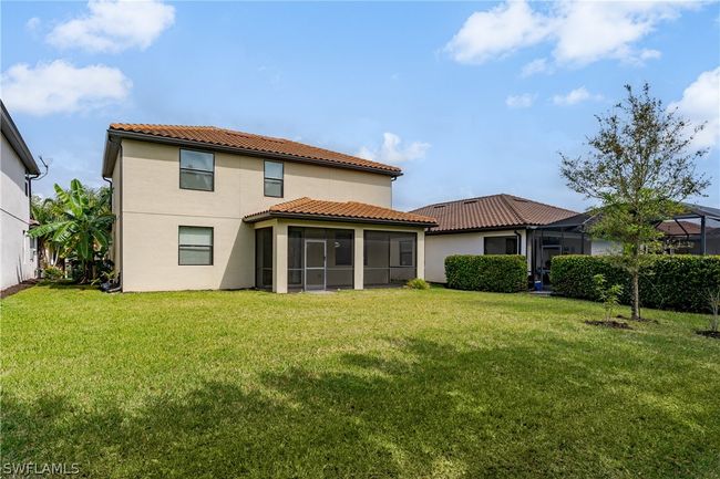 Rear view of house featuring a yard and glass enclosure | Image 33
