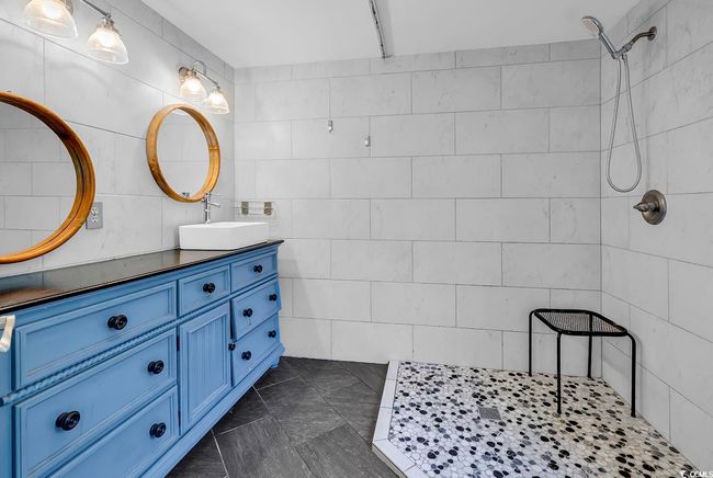 Full bath with double vanity, tiled shower, and tile walls | Image 15